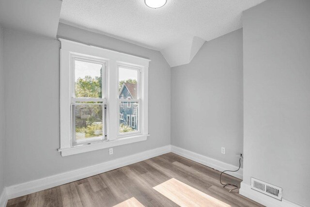 1912 15th Ave N, Minneapolis, MN 55411 - bonus room featuring a textured ceiling, wood finished floors, baseboards, and lofted ceiling