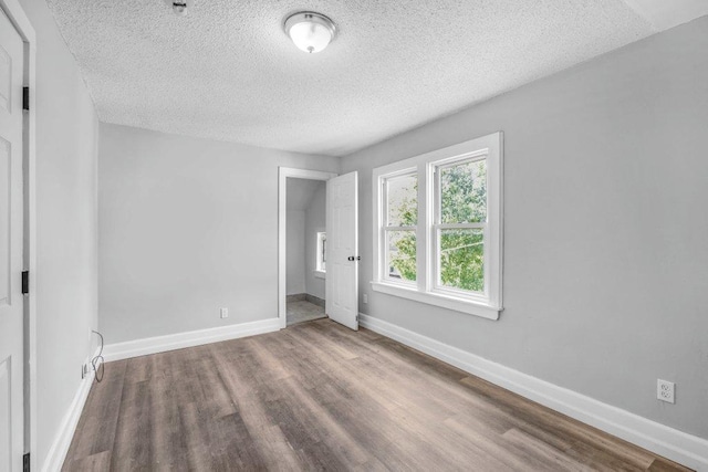 1912 15th Ave N, Minneapolis, MN 55411 - unfurnished bedroom with a textured ceiling, wood finished floors, and baseboards