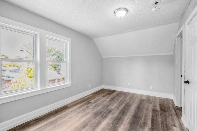 1912 15th Ave N, Minneapolis, MN 55411 - additional living space featuring wood finished floors, a textured ceiling, lofted ceiling, and baseboards