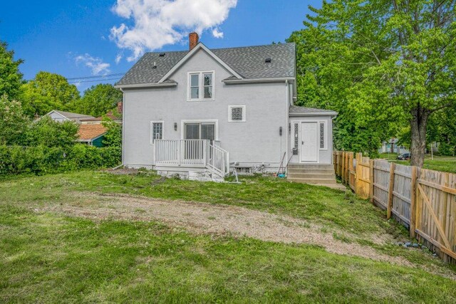 1912 15th Ave N, Minneapolis, MN 55411 - back of property featuring a shingled roof, a chimney, and stucco siding