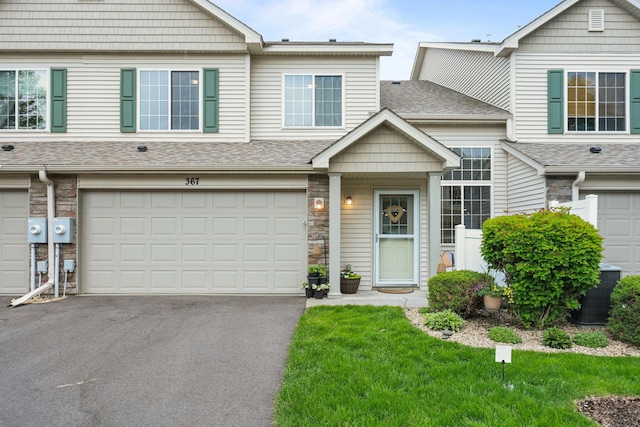 367 Ojibway Path, Lino Lakes, MN 55014 - view of property with an attached garage, driveway, stone siding, roof with shingles, and central AC unit