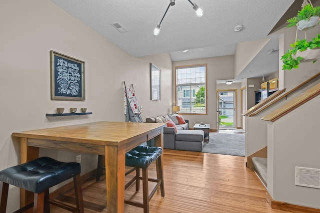 367 Ojibway Path, Lino Lakes, MN 55014 - dining space with stairs, light wood-style flooring, a textured ceiling, and track lighting