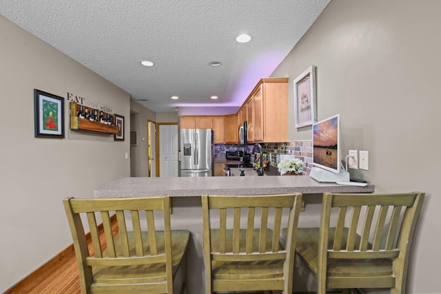 367 Ojibway Path, Lino Lakes, MN 55014 - kitchen with stainless steel appliances, a textured ceiling, recessed lighting, decorative backsplash, and light wood-style flooring