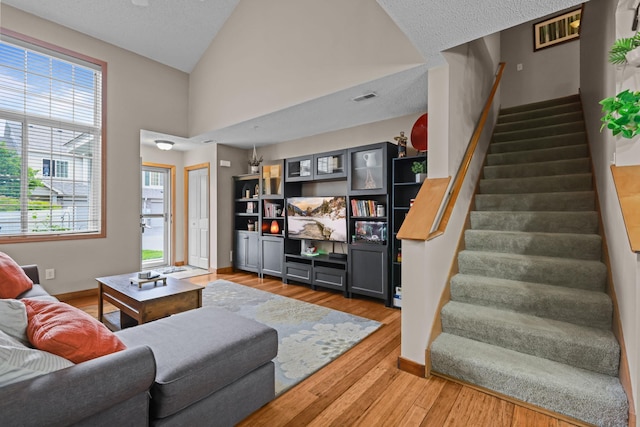 367 Ojibway Path, Lino Lakes, MN 55014 - living room with stairs, light wood-type flooring, baseboards, and high vaulted ceiling