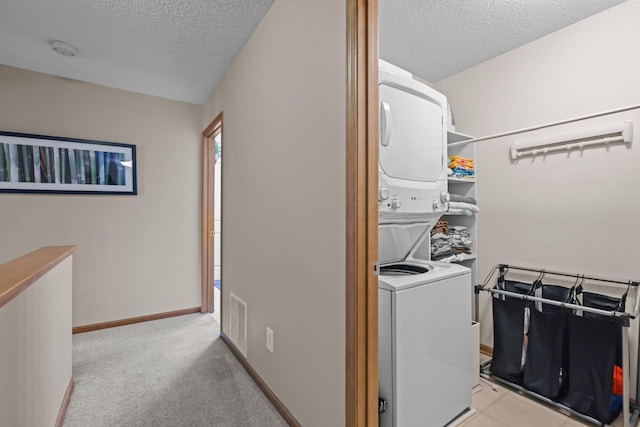 367 Ojibway Path, Lino Lakes, MN 55014 - laundry room featuring stacked washer and clothes dryer, a textured ceiling, light carpet, and baseboards