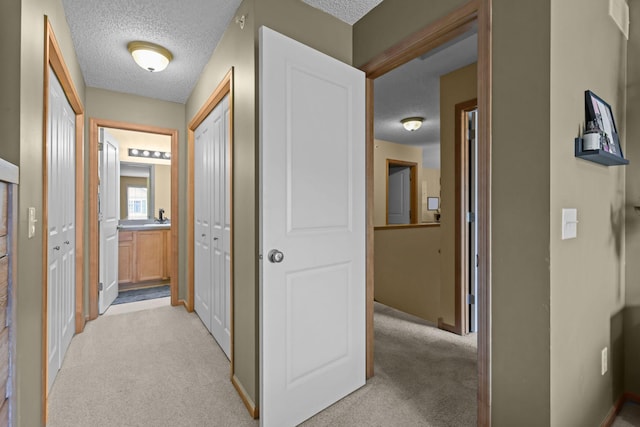 367 Ojibway Path, Lino Lakes, MN 55014 - hallway with a textured ceiling, light colored carpet, and baseboards