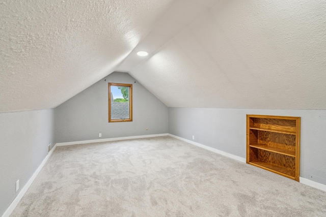 3945 15th Ave S, Minneapolis, MN 55407 - bonus room featuring a textured ceiling, vaulted ceiling, carpet floors, and baseboards