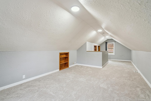 3945 15th Ave S, Minneapolis, MN 55407 - additional living space featuring a textured ceiling, lofted ceiling, carpet flooring, and baseboards
