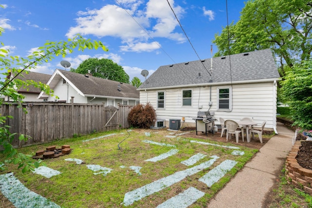 3945 15th Ave S, Minneapolis, MN 55407 - back of house with central AC unit, a shingled roof, a gate, and a patio