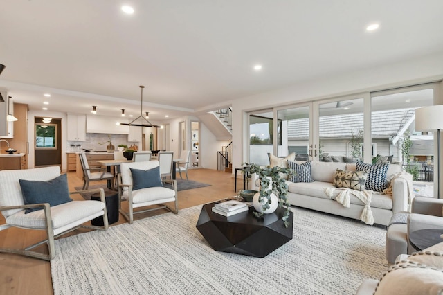 living room featuring stairway, recessed lighting, and light wood-style floors