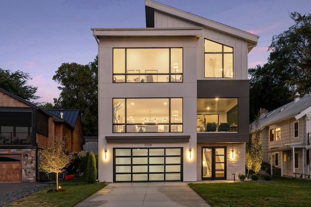 contemporary house featuring driveway, a yard, and an attached garage
