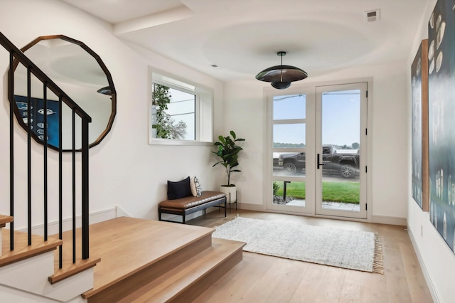 foyer entrance with wood finished floors, baseboards, stairway, and french doors