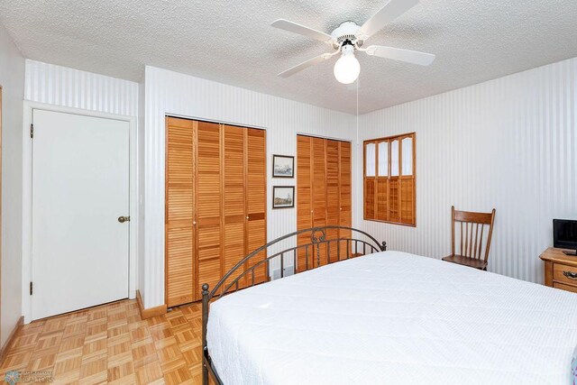 1209 5th St N, Fargo, ND 58102 - bedroom featuring two closets, a textured ceiling, and a ceiling fan
