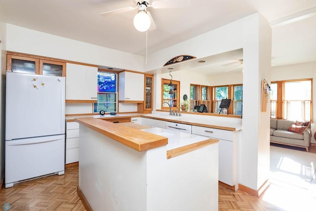 1209 5th St N, Fargo, ND 58102 - kitchen featuring freestanding refrigerator, ceiling fan, white cabinets, a sink, and light countertops