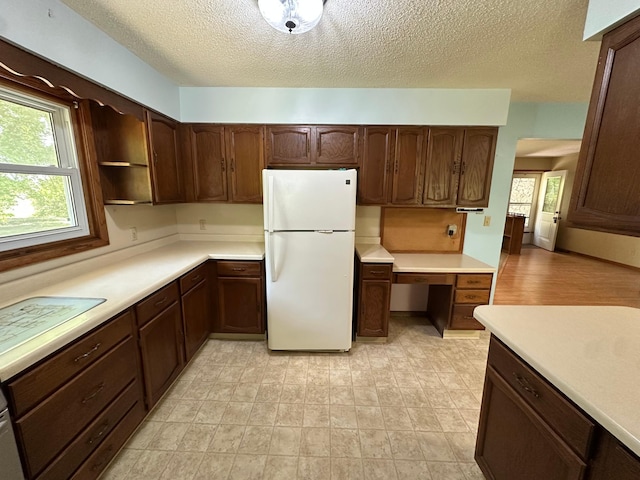 14390 Sperry Lake Rd, Harrison Twp, MN 56209 - kitchen featuring freestanding refrigerator, light countertops, a textured ceiling, healthy amount of natural light, and dark brown cabinets