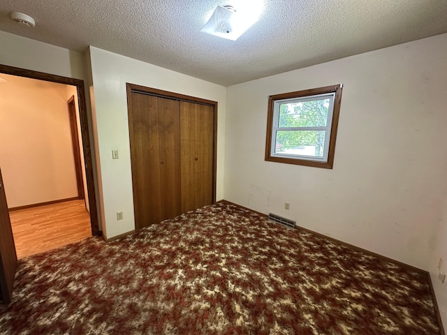 14390 Sperry Lake Rd, Harrison Twp, MN 56209 - unfurnished bedroom featuring a closet, carpet, and a textured ceiling
