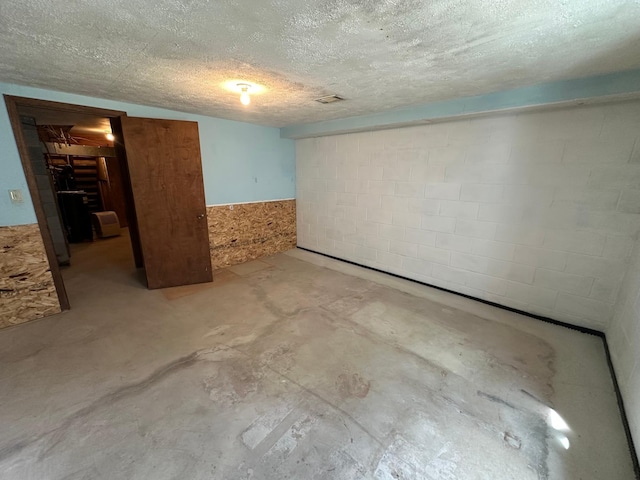 14390 Sperry Lake Rd, Harrison Twp, MN 56209 - unfurnished bedroom with concrete flooring, concrete block wall, and a textured ceiling