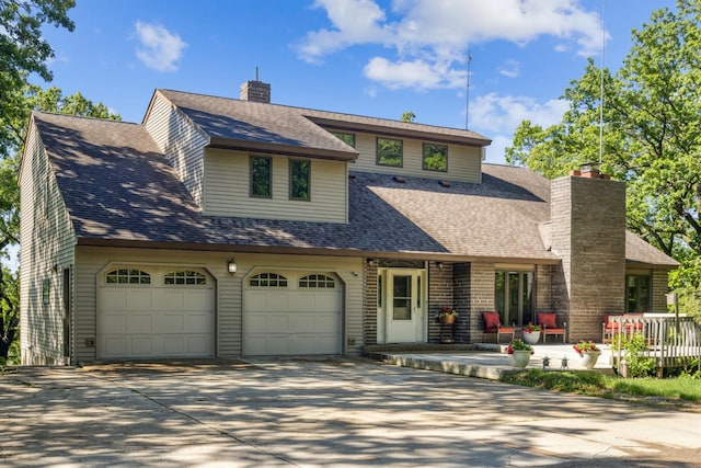 12975 185th St, Cold Spring, MN 56320 - view of front of home featuring concrete driveway, a shingled roof, and a chimney