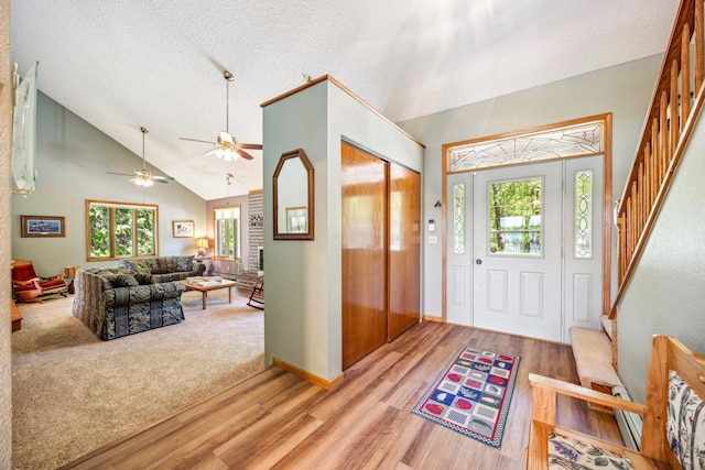 12975 185th St, Cold Spring, MN 56320 - foyer with light wood finished floors, a textured ceiling, stairway, high vaulted ceiling, and ceiling fan