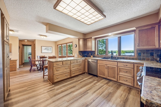 12975 185th St, Cold Spring, MN 56320 - kitchen featuring stainless steel appliances, a textured ceiling, a peninsula, a sink, and light wood-type flooring