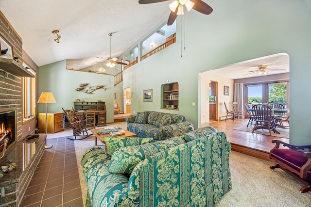 12975 185th St, Cold Spring, MN 56320 - living room featuring ceiling fan, a textured ceiling, a fireplace, and high vaulted ceiling