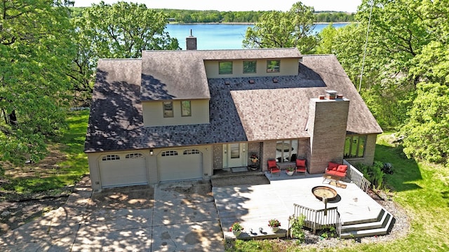 12975 185th St, Cold Spring, MN 56320 - view of front of property featuring a chimney, an outdoor fire pit, driveway, and a deck with water view