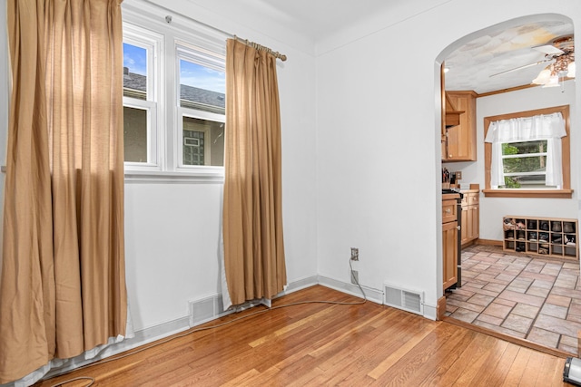 1344 Schletti St, Saint Paul, MN 55117 - empty room featuring a ceiling fan, arched walkways, baseboards, and light wood finished floors