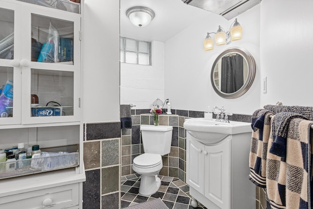 1344 Schletti St, Saint Paul, MN 55117 - bathroom with tile walls, vanity, toilet, wainscoting, and tile patterned floors