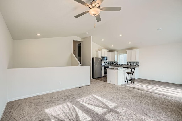 39685 Fallbrook Ave, North Branch, MN 55056 - living room with lofted ceiling, light carpet, ceiling fan, recessed lighting, and baseboards