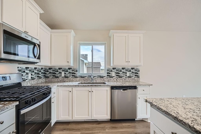 39685 Fallbrook Ave, North Branch, MN 55056 - kitchen with stainless steel appliances, a sink, tasteful backsplash, light wood-style floors, and white cabinetry