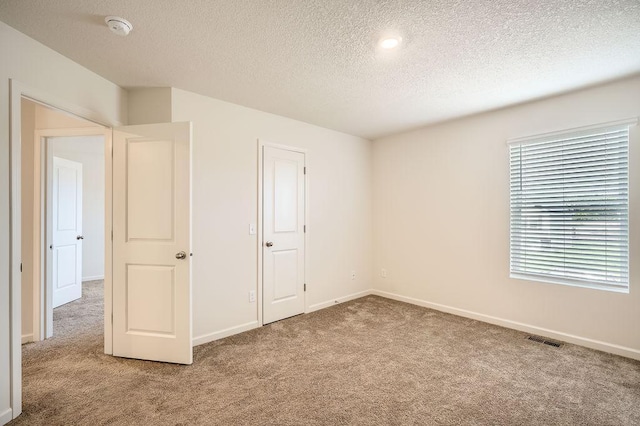 39685 Fallbrook Ave, North Branch, MN 55056 - unfurnished bedroom featuring carpet flooring, a textured ceiling, and baseboards