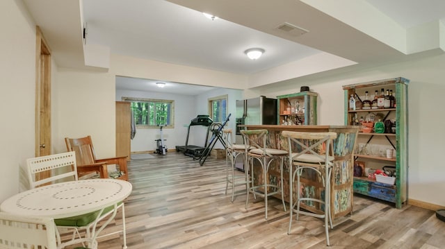 3015 Aspen Ter, Scott Twp, WI 54830 - indoor dry bar with wood finished floors, stainless steel fridge with ice dispenser, and baseboards