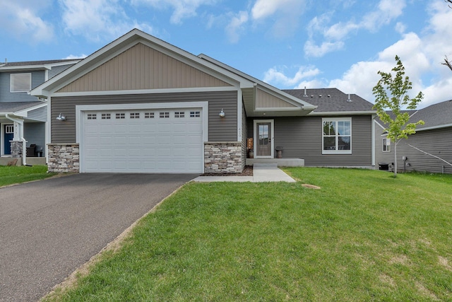 419 Bluebird Dr NW, Isanti, MN 55040 - view of front of house with asphalt driveway, an attached garage, a front yard, stone siding, and central AC unit