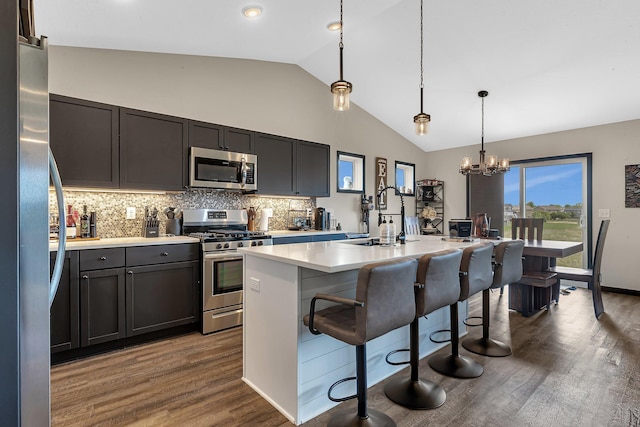 419 Bluebird Dr NW, Isanti, MN 55040 - kitchen with appliances with stainless steel finishes, light countertops, dark wood-style floors, a kitchen bar, and a sink
