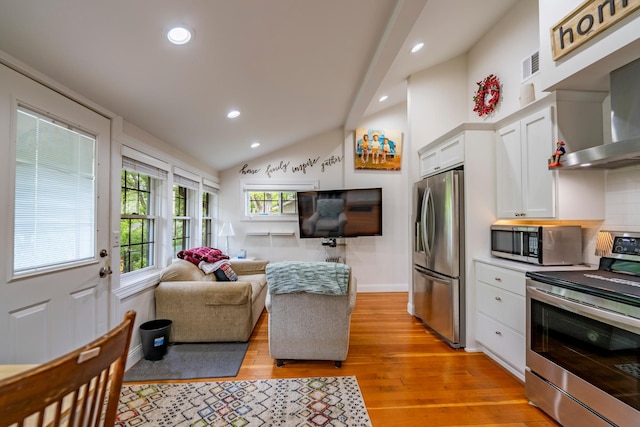 30124 Circle Dr, Breezy Point, MN 56472 - kitchen with stainless steel appliances, wall chimney exhaust hood, white cabinets, recessed lighting, and light wood-type flooring