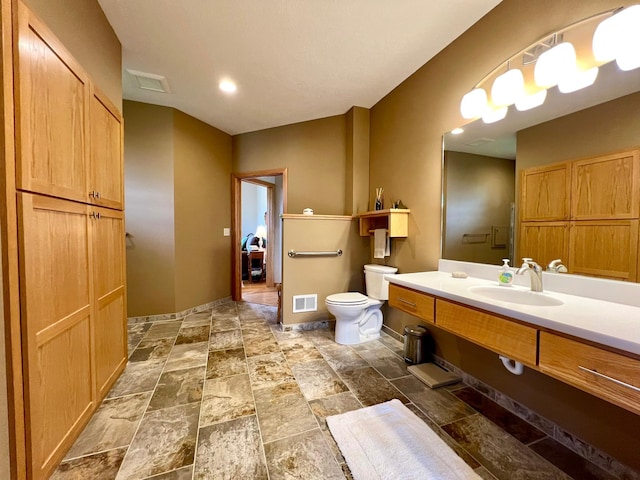 2774 Pine Ridge Blvd, Red Wing, MN 55066 - bathroom with toilet, vanity, baseboards, and stone finish flooring