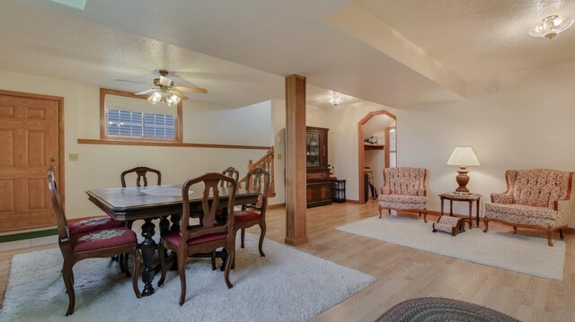 9020 120th Ave, Tilden Twp, WI 54724 - dining space with light wood finished floors, ceiling fan, arched walkways, a textured ceiling, and baseboards