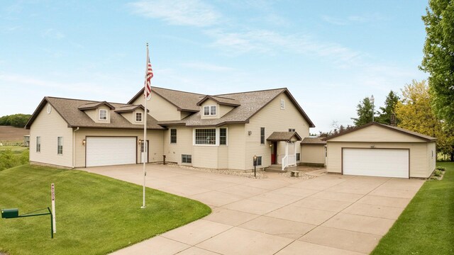 9020 120th Ave, Tilden Twp, WI 54724 - view of front of property with a front yard, a detached garage, a shingled roof, and an outbuilding