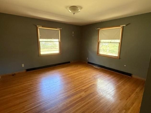 510 2nd Ave NW, Milaca, MN 56353 - unfurnished room featuring plenty of natural light, wood finished floors, and baseboards