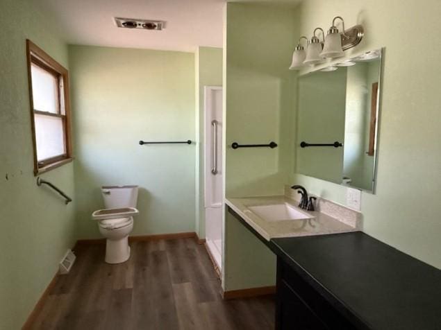 510 2nd Ave NW, Milaca, MN 56353 - bathroom featuring wood finished floors, vanity, toilet, and baseboards