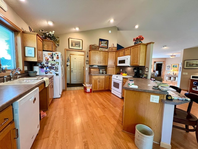964 Aurora Cir, Red Wing, MN 55066 - kitchen with white appliances, a sink, a peninsula, light wood-style floors, and a breakfast bar area