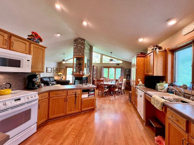 964 Aurora Cir, Red Wing, MN 55066 - kitchen featuring white appliances, a ceiling fan, a peninsula, lofted ceiling, and brown cabinets