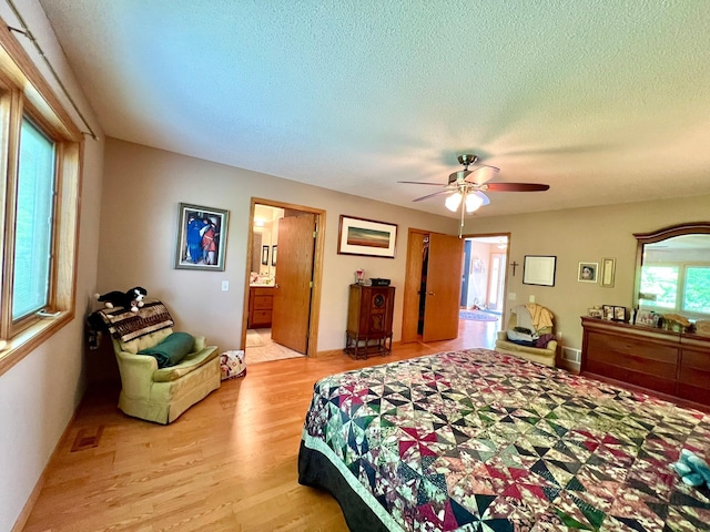 964 Aurora Cir, Red Wing, MN 55066 - bedroom featuring light wood finished floors, a textured ceiling, ensuite bath, and ceiling fan