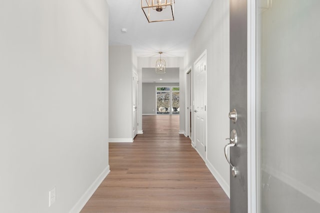 1957 Woods Pt, Waconia, MN 55387 - corridor featuring a chandelier, light wood-type flooring, and baseboards