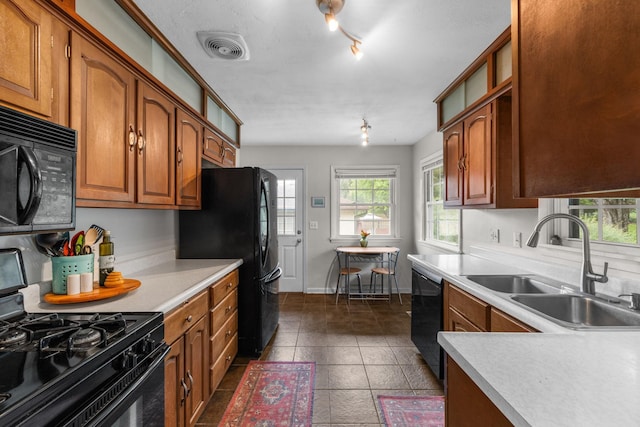 4065 Jersey Ave N, Crystal, MN 55427 - kitchen featuring black appliances, light countertops, brown cabinets, and dark tile patterned floors