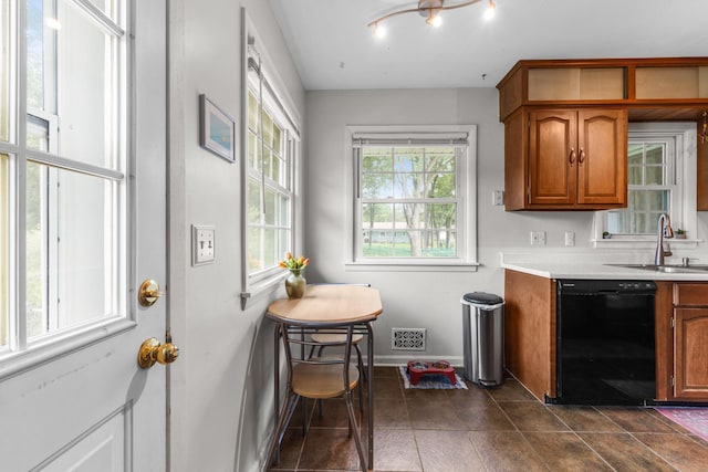 4065 Jersey Ave N, Crystal, MN 55427 - kitchen featuring black dishwasher, brown cabinetry, light countertops, and dark tile patterned floors