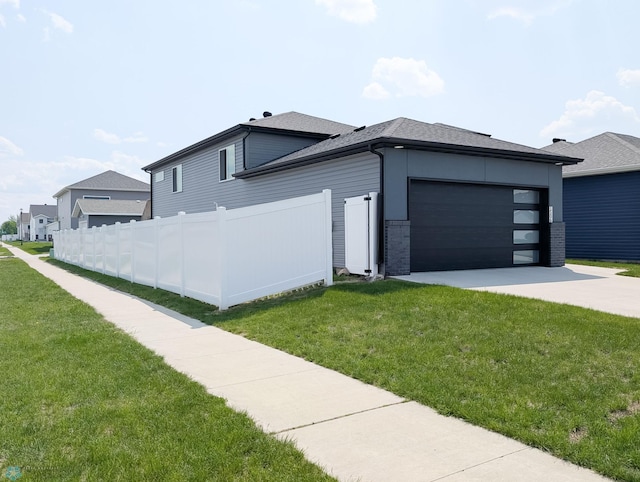 1506 67th Ave S, Fargo, ND 58104 - view of home's exterior featuring an attached garage, driveway, and a shingled roof