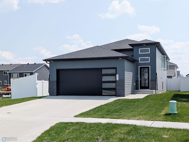 1506 67th Ave S, Fargo, ND 58104 - view of front facade featuring driveway, a garage, and a shingled roof