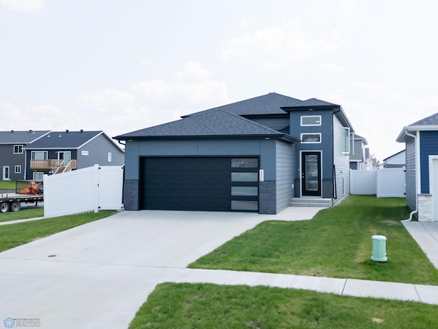 1506 67th Ave S, Fargo, ND 58104 - view of front of house with a garage, driveway, brick siding, and a shingled roof