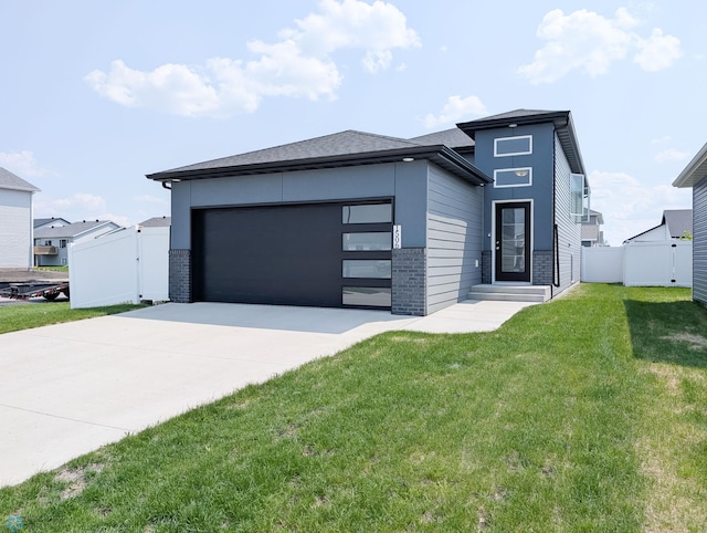 1506 67th Ave S, Fargo, ND 58104 - view of front facade with concrete driveway, a garage, and brick siding